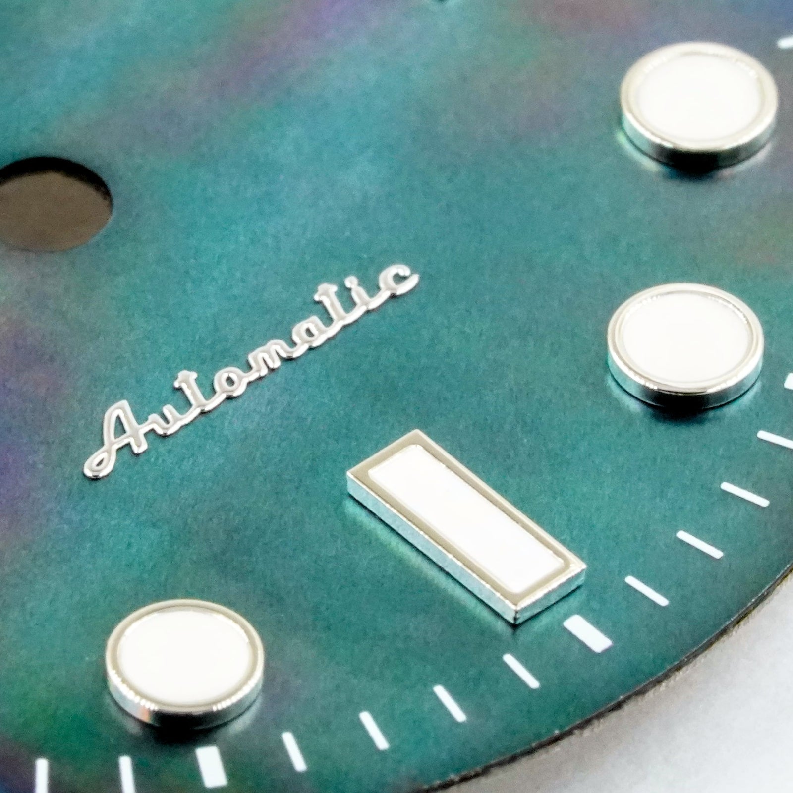 Angled view of the black mother of pearl Submariner II dial showing the iridescence shifting across the surface under raking light