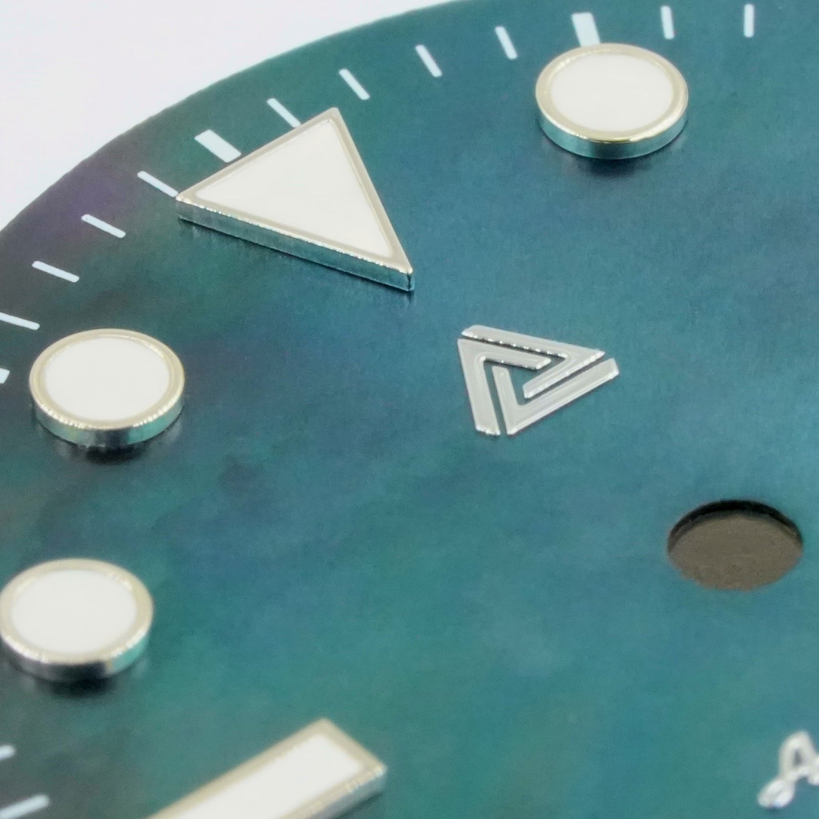 Macro of the black mother of pearl Submariner II date dial — bevelled applied silver indices, printed white minute track and the 3 o'clock date aperture