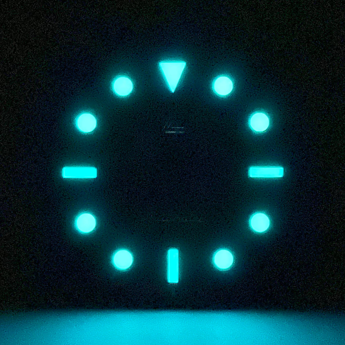 Lume shot of the no-date glossy black enamel Submariner II dial — BGW9 A-Grade lume glowing cool blue against the dark dial